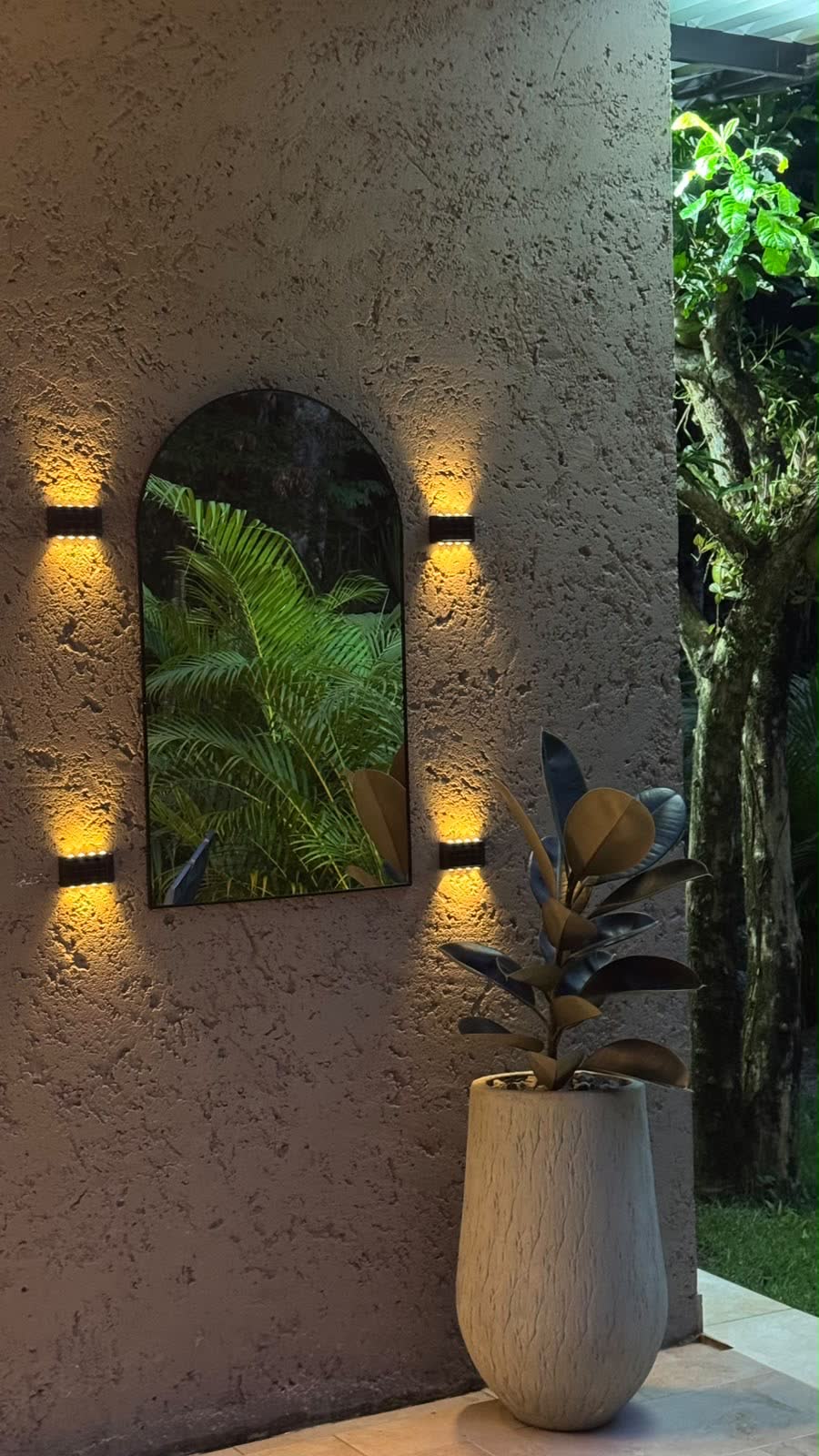 Muro de piedra con espejo en arco y luces